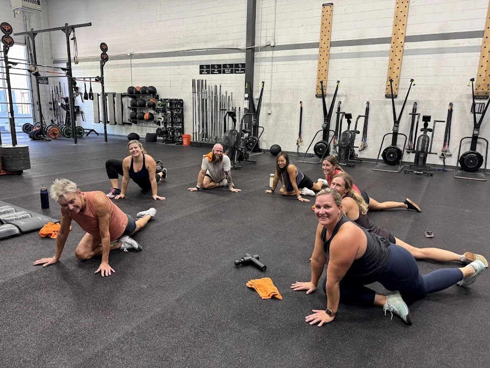 Members smiling and stretching together at Synergy Johns Creek